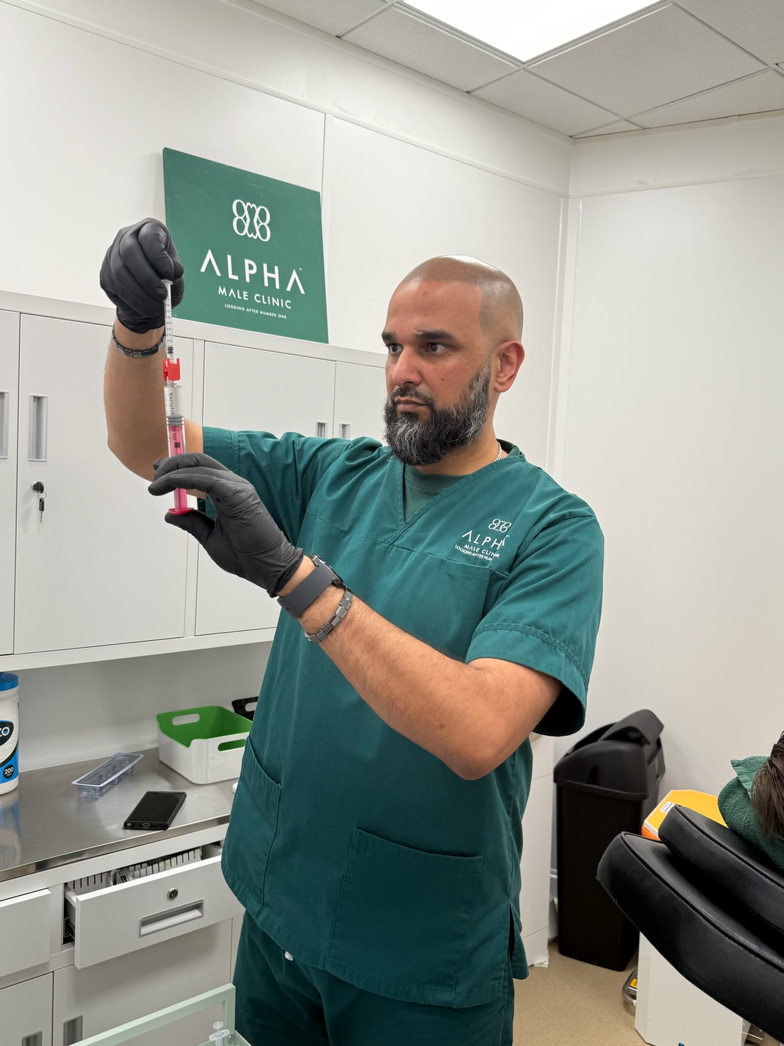 Dr Mustafa Ganijee checking a filler syringe in the treatment room