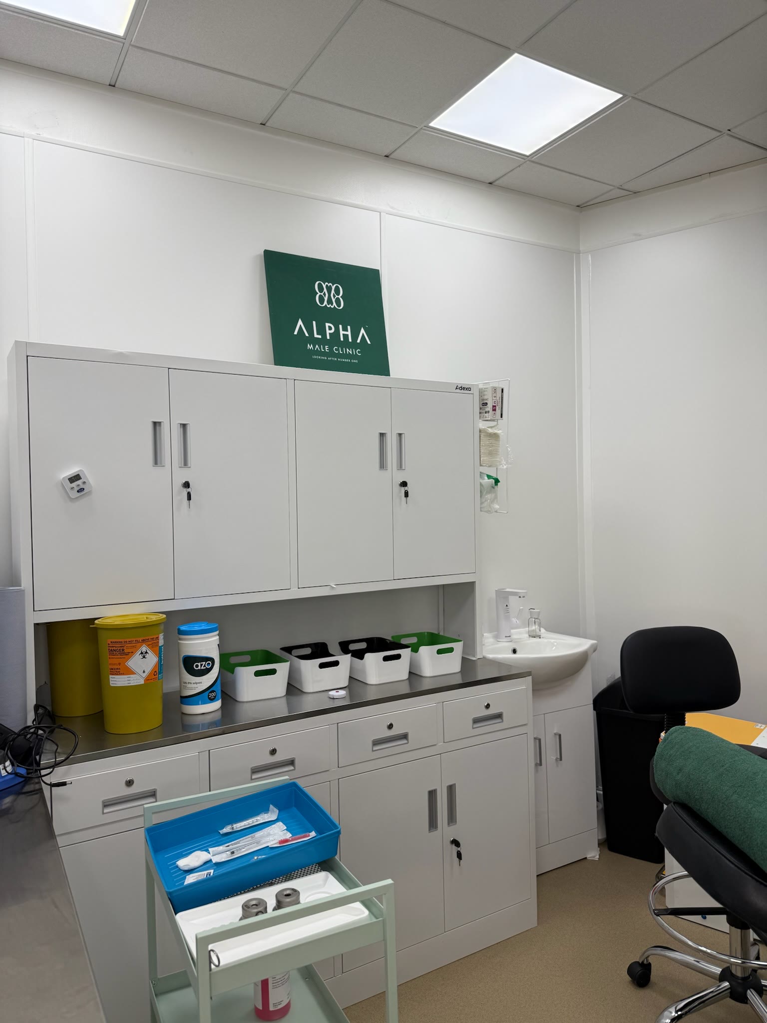Treatment room at Alpha Male Clinic with couch, sink and sealed instrument tray